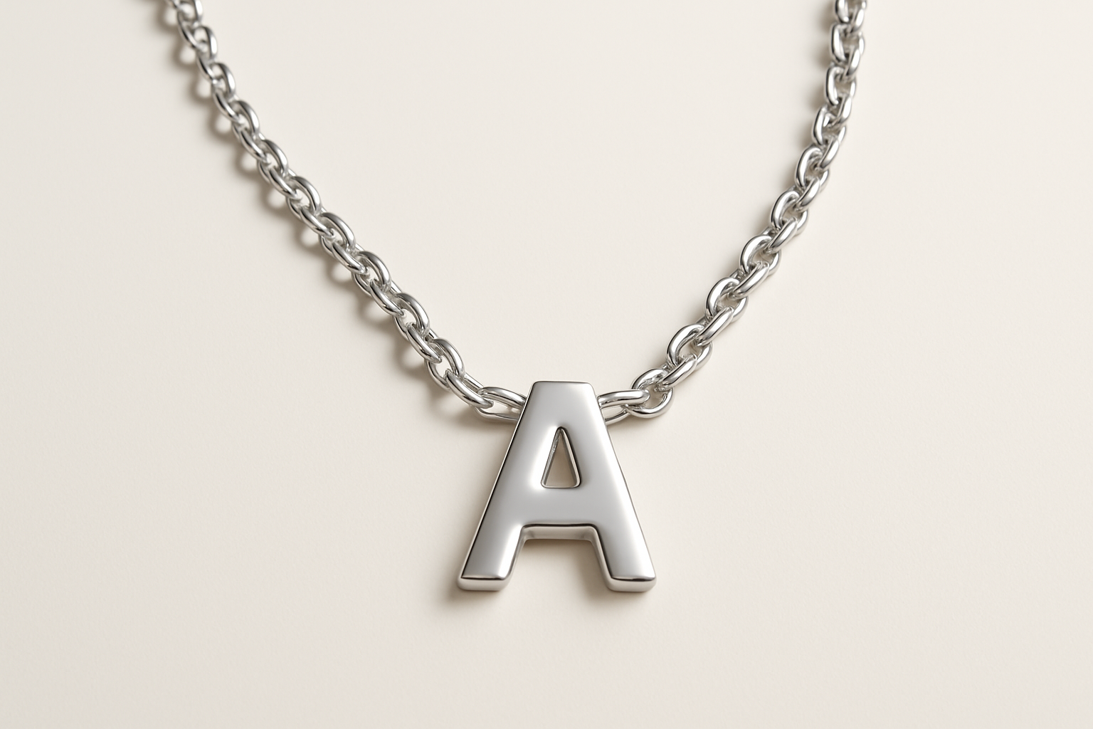Professional studio image of silver chain necklace with letter A pendant