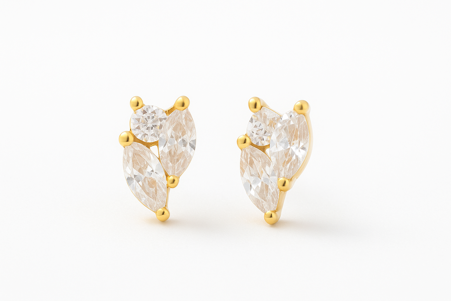 Professional studio photograph of 14k gold triple diamante stud earrings